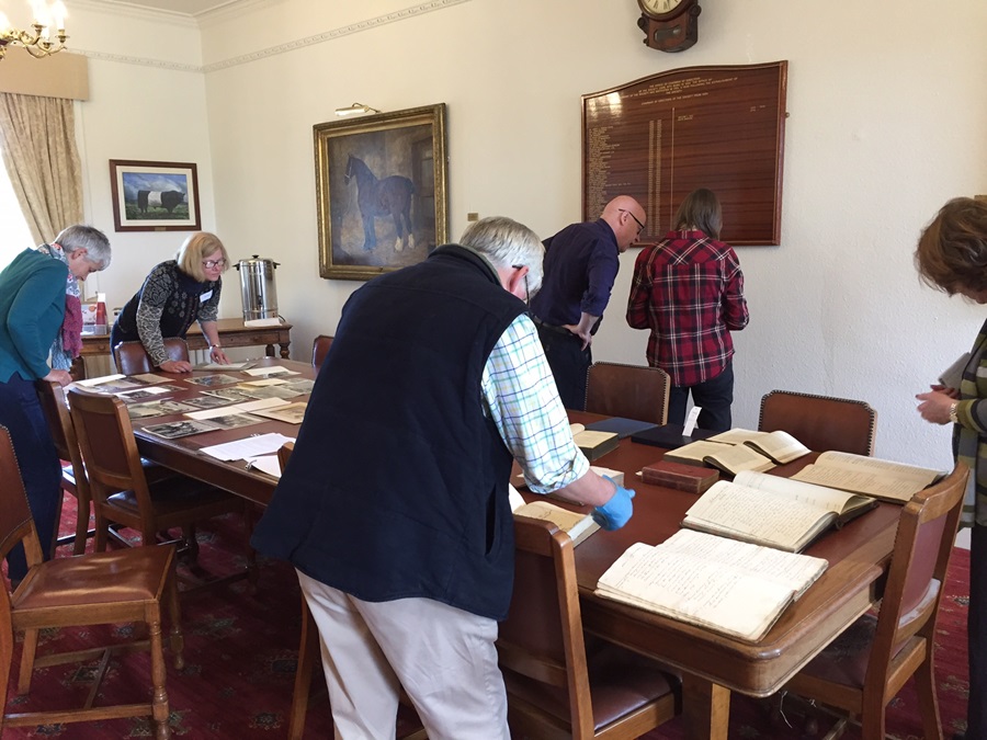 Members of the group look at archival materials at the Royal Highland and Agricultural Society of Scotland.