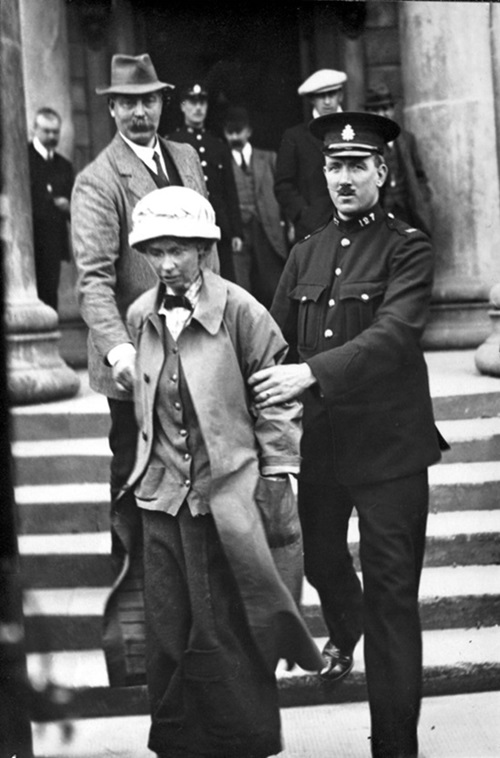 Suffragette Fanny Parker, alias Janet Arthur, being escorted from Ayr Sheriff Court, 1914. Crown copyright, National Records of Scotland, HH16/43/58